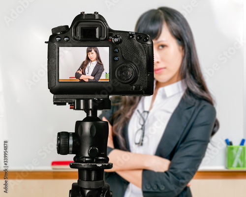 Asian American teacher streaming class with camera