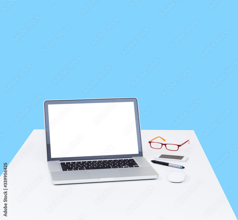 Laptop computer on desk with isolated screen for mockup on blue background. business and technology concept Laptop computer on desk with isolated screen for mockup on blue background. business and technology concept