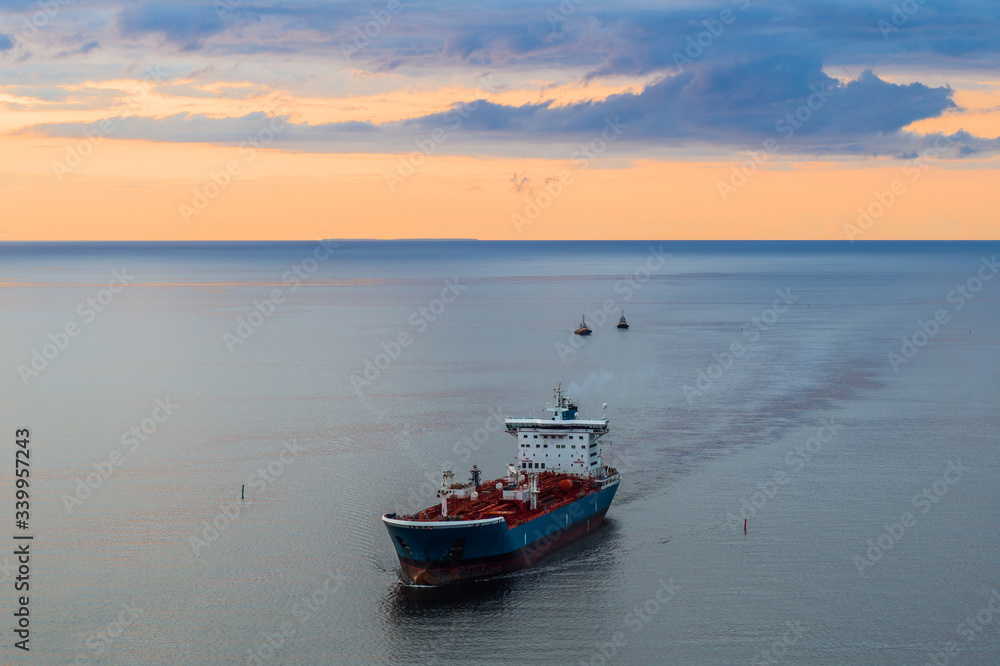Tanker at sea, aerial view. Large blue and white ship in the bay at sunset.