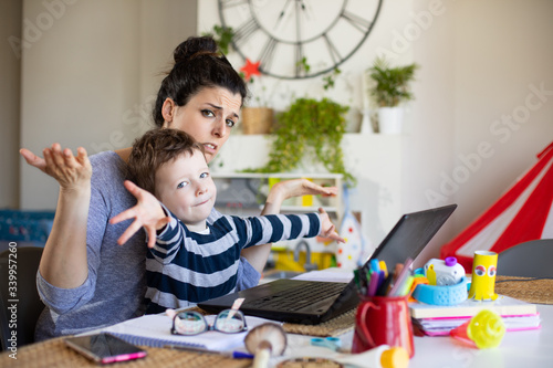 Obraz na plátně Busy mother working from home and taking care of her child