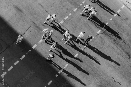 Street photo of people crossing the road at a pedestrian crossing. View from above