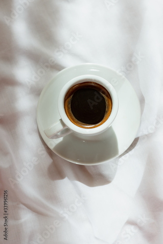 
Cup of coffee on a white sheet background. Minimalism. Monochrome. Place for text. Lifestyle. Home furnishings. Stylish photo. Morning. Flat lay