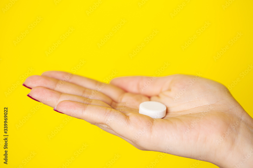 Woman holds white pill in her hand for weight loss Woman holds white pill in her hand for weight loss