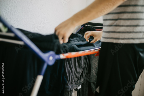 Man doing his laundry at home, washing and folding clothes.