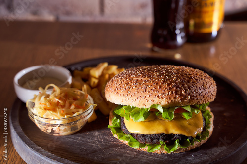burger with sesame seeds with fries and salad of cabbage closeup