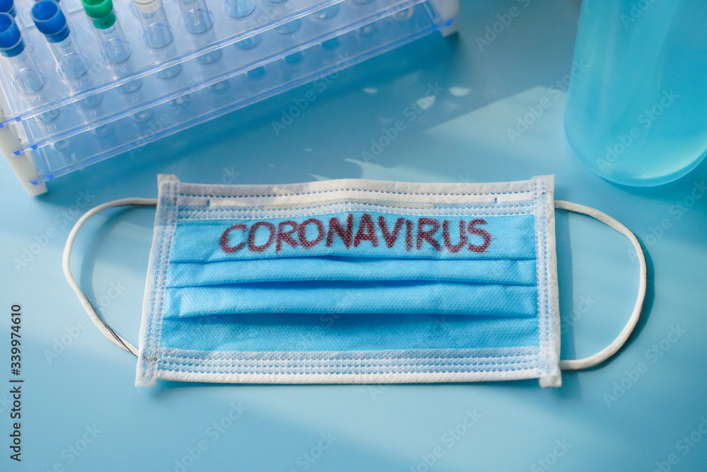 Medical face mask with coronavirus printed on it and Test tube, alcohal gel, Rubber gloves. with copy space. Medical face mask with coronavirus printed on it and Test tube, alcohal gel, Rubber gloves. with copy space.