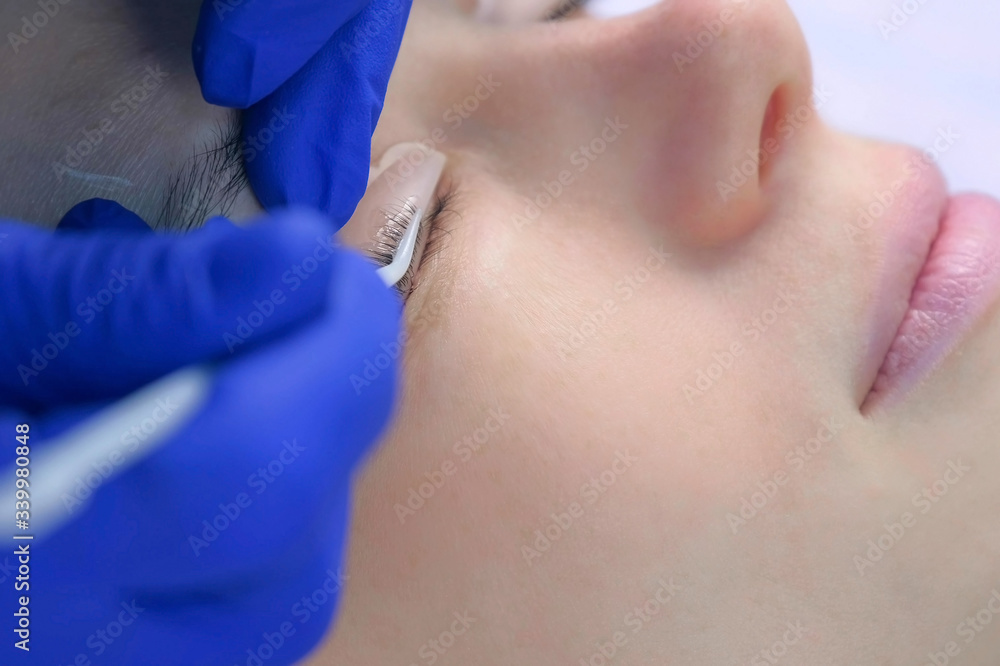 Cosmetologist bending lashes with needle into curlers, lift eyelashes laminaton procedure in beauty salon for woman, closeup eye. Beautician making lash lifting in cosmetology clinic, hands closeup. Cosmetologist bending lashes with needle into curlers, lift eyelashes laminaton procedure in beauty salon for woman, closeup eye. Beautician making lash lifting in cosmetology clinic, hands closeup.