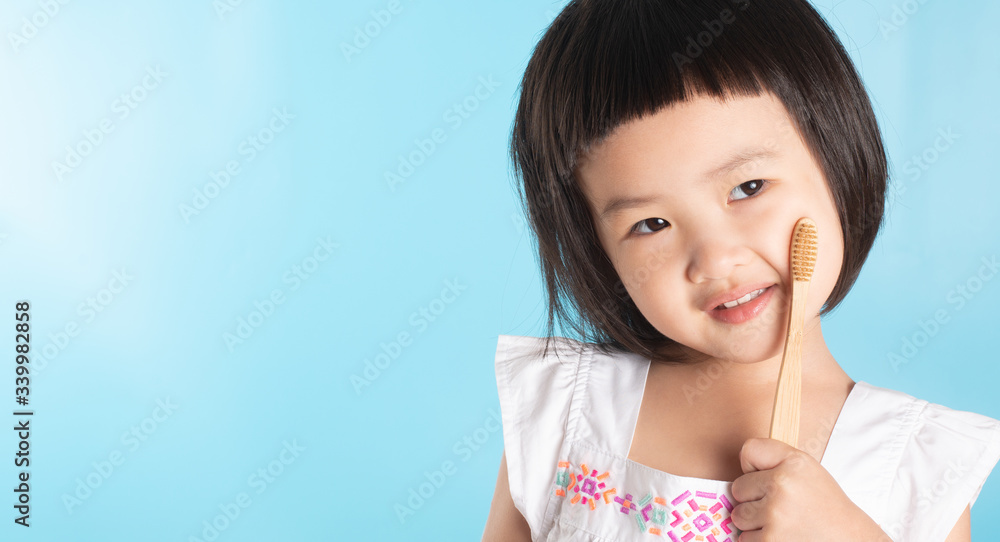 Cute Asian girl holding a toothbrush to clean her teeth and copy space. Cute Asian girl holding a toothbrush to clean her teeth and copy space.