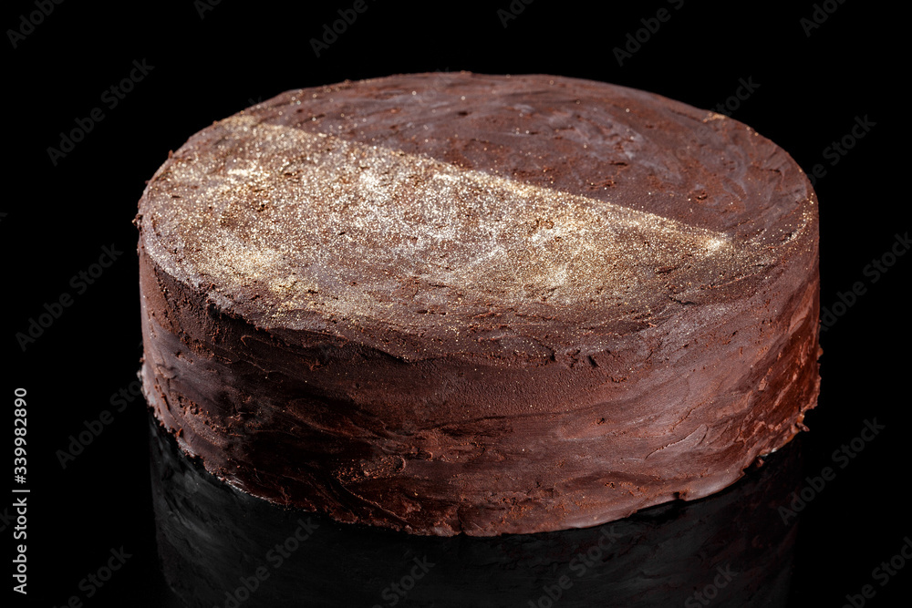 Fototapeta premium Lava chocolate cake with gold edible glitter on top. Confectionery photography concept in black background.