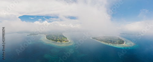 Amazing aerial view to Gili islands and Lombok. Unforgettable experience during vacations holidays. Blue sky and lagoon water. Clouds on the horizon. Air, Meno, Trawangan.