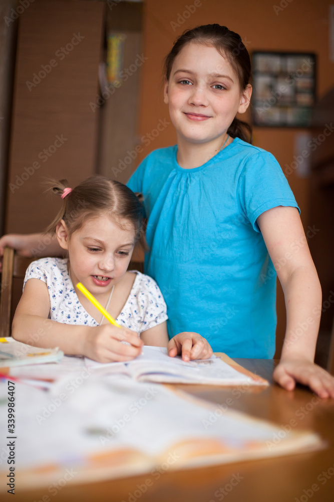 Older sister helping younger sister with her studies Older sister helping younger sister with her studies