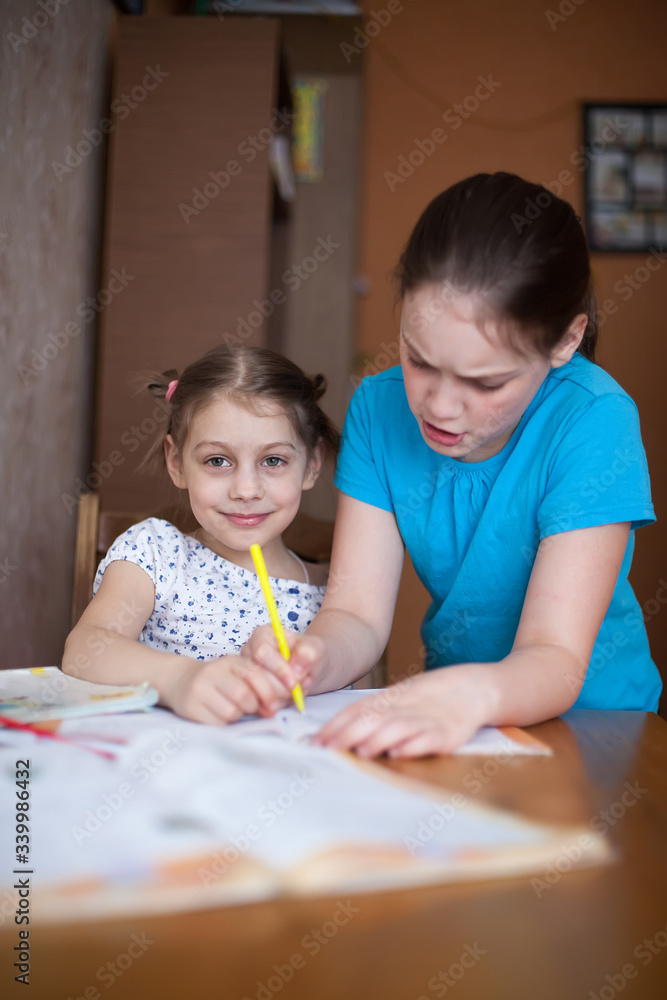 Older sister helping younger sister with homework Older sister helping younger sister with homework