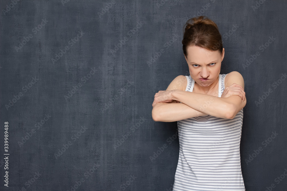 Portrait of funny angry girl with holding arms crossed on chest Portrait of funny angry girl with holding arms crossed on chest