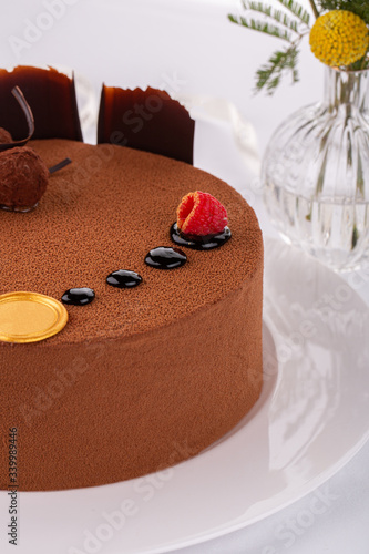 Truffle cake with truffle candy, grated chocolate and fresh raspberry photo