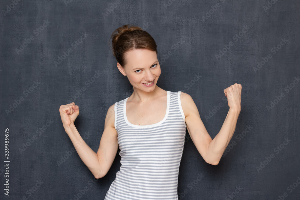 Portrait of happy girl raising fists up, celebrating achievements Portrait of happy girl raising fists up, celebrating achievements