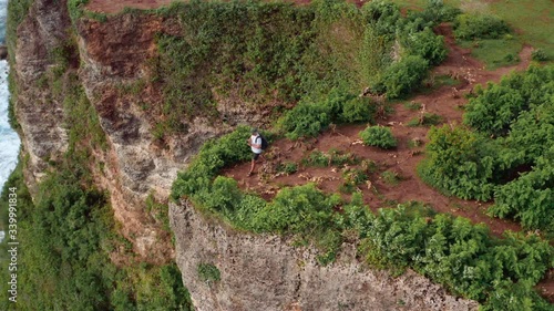 Wallpaper Mural Aerial drone view of happy sporty plus size man traveler use his mobile device smartphone on a mountain cliff. Guy use online or offline maps and GPS satellites for travelling with navigation device. Torontodigital.ca