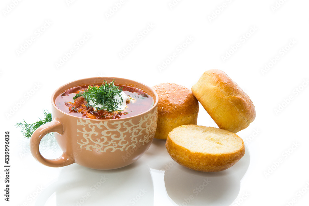 hot beetroot soup with sour cream, herbs and rolls in a ceramic bowl hot beetroot soup with sour cream, herbs and rolls in a ceramic bowl