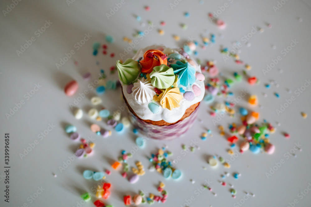 Easter cake with sweet figures on the glaze, standing on the kitchen table, which is strewn with sweet ingredients Easter cake with sweet figures on the glaze, standing on the kitchen table, which is strewn with sweet ingredients