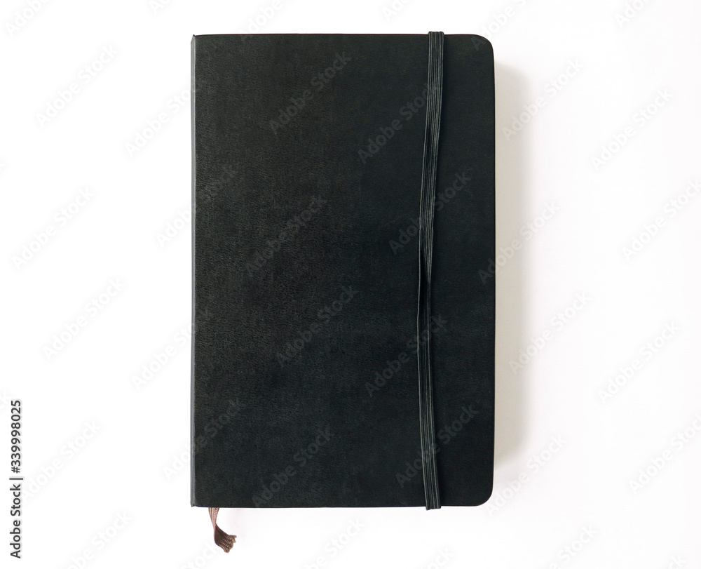Aerial view of closed black travel notebook with elastic isolated on white background. Vintage stationery. Aerial view of closed black travel notebook with elastic isolated on white background. Vintage stationery.