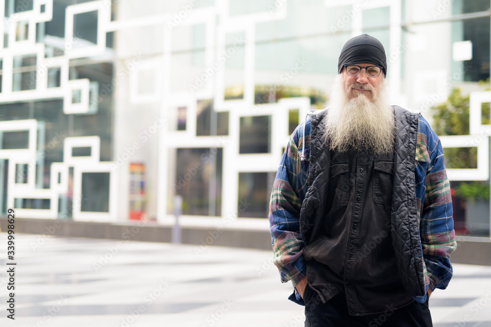 Mature handsome bearded man wearing eyeglasses in the city outdoors Mature handsome bearded man wearing eyeglasses in the city outdoors