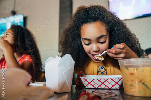 Girl eating take out food with chopsticks