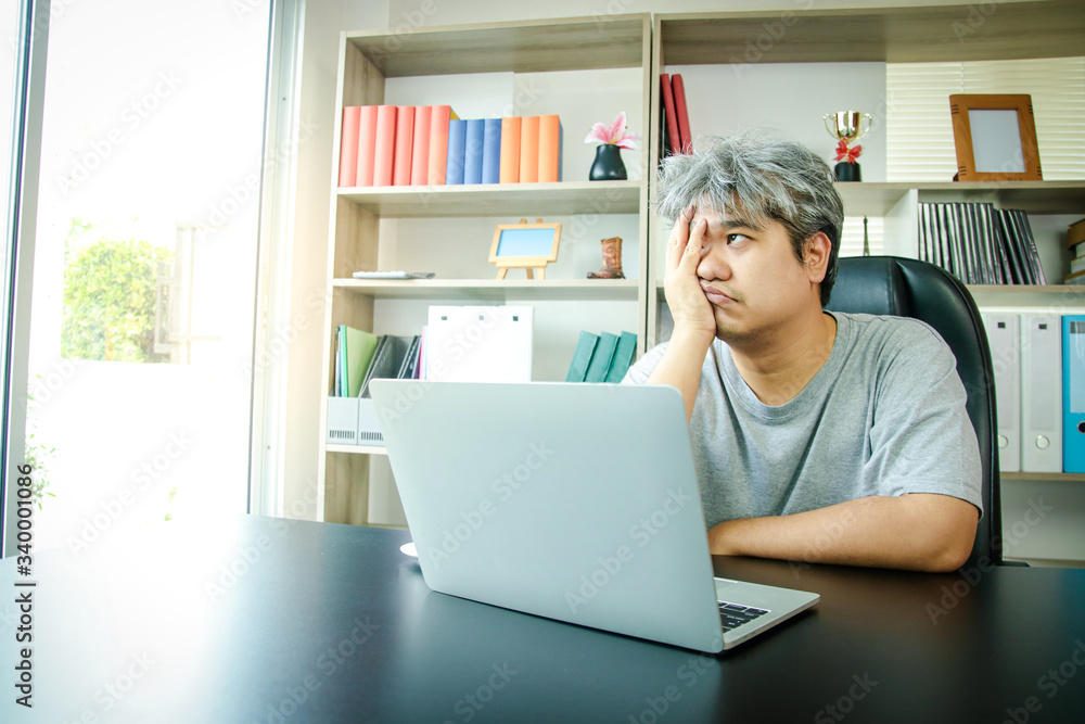 Asian people work at home in the office. There is stress meeting online work on notebook computers. The concept of entrepreneur, freelance, social distancing against coronavirus (covid-19)