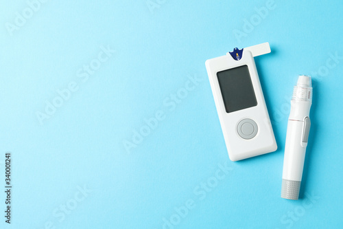 Blood glucose meter on blue background, space for text