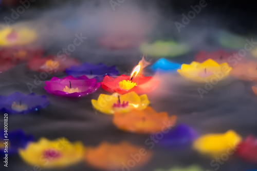 Spiritual inspirational candle light burning floating in the water with smoke.