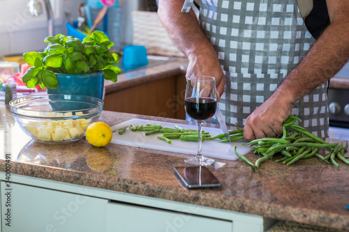 Close up of adult man cutting vegetables at home in the kitchen - healthy vegetarian lifestyle and natural food ingredients cooking photo