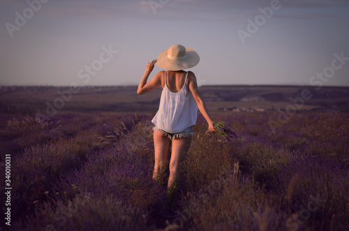 Back view portrait of the young beautiful girl in th e lavender field.