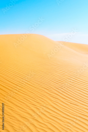 Desert, textured sand dune and blue sky