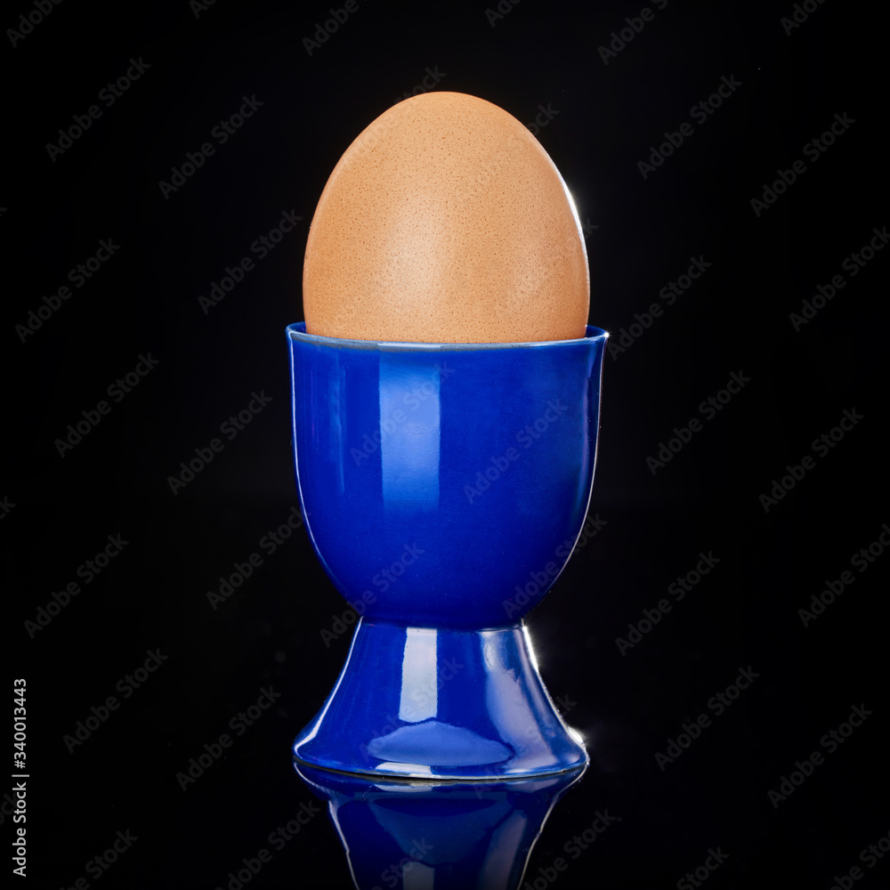 Egg in the stand on a black background in the studio Egg in the stand on a black background in the studio