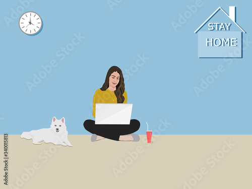 A woman sitting using a notebook in the house . The white dog sat beside. There was a character stay home on the wall