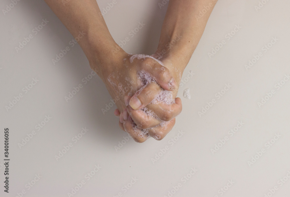 Fototapeta premium Overhead shot of washing hands with soap to keep germs away and for prevention of coronavirus, co-vid 19 diseases from spreading on white background
