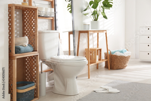 Interior of stylish bathroom with toilet bowl and decor elements