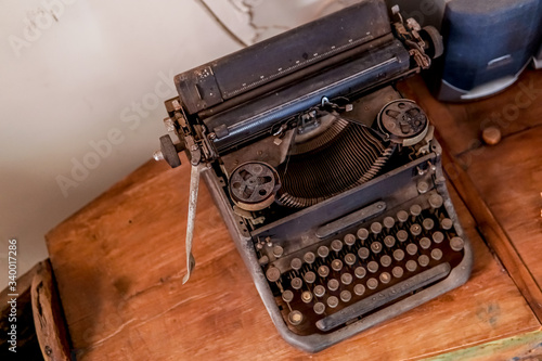 a dusty black antique typewriter on the table