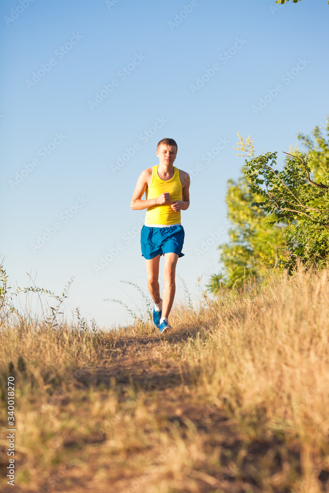Young man running on a rural road during sunset Young man running on a rural road during sunset