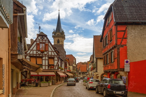 Street, houses and church towers in Obernai by day, Alsace, France