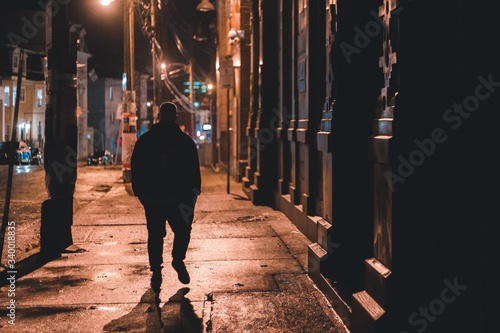 Slika na platnu shadowy figure walking down street at night in St