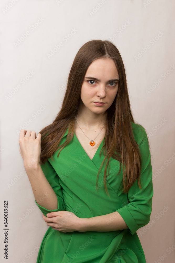 close-up portrait of a blonde long-haired romantic girl with big gray eyes in a green dress close-up portrait of a blonde long-haired romantic girl with big gray eyes in a green dress