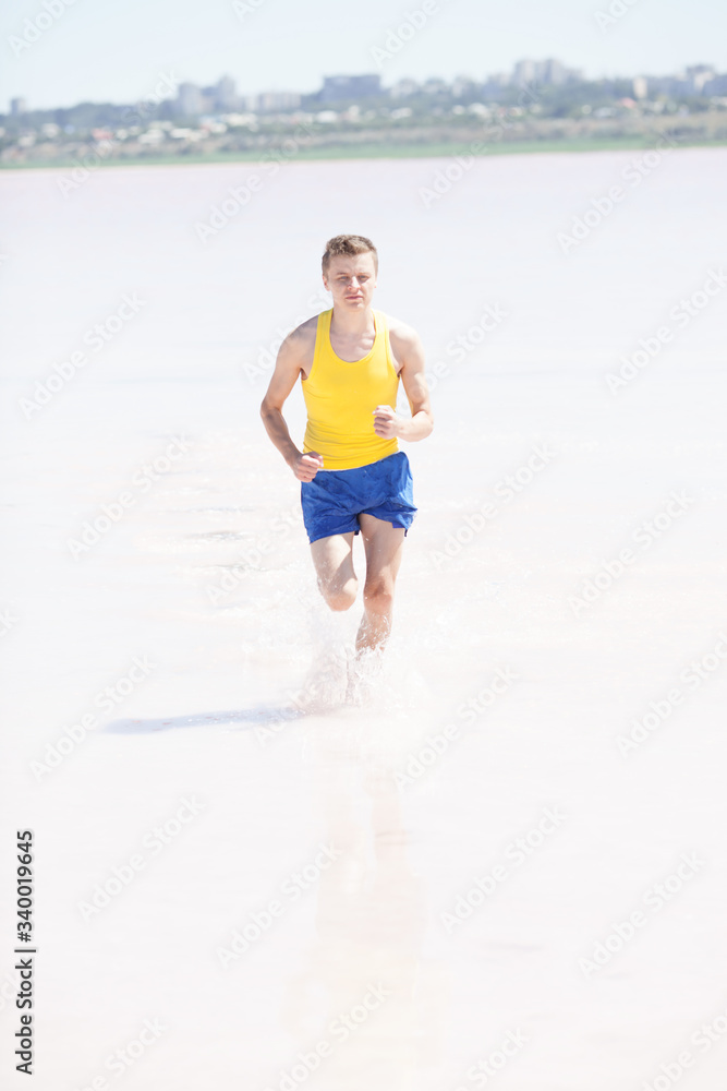 Man running in water on the beach Man running in water on the beach