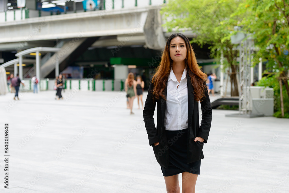 Young beautiful Asian businesswoman in the city streets