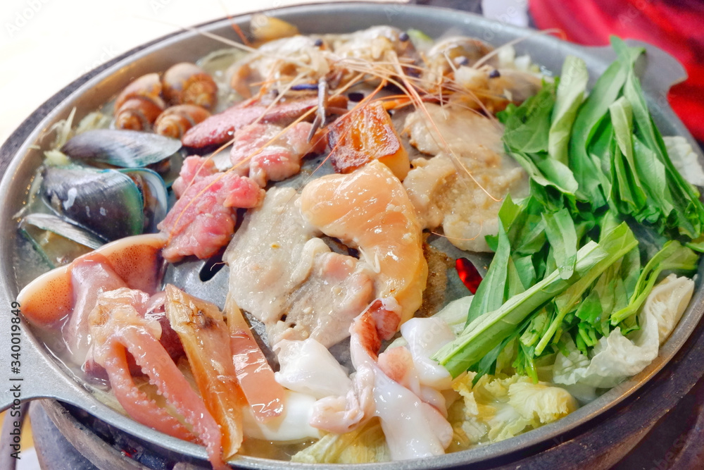 Sliced Pork and seafood on Thai Styled Coal Grill and Shabu Pan.Shrimp Clams in a Hot Pan.Close up.
Sliced Pork and seafood on Thai Styled Coal Grill and Shabu Pan.Shrimp Clams in a Hot Pan.Close up.