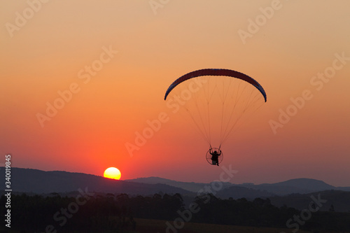 paramotor flying silhouette at sunset