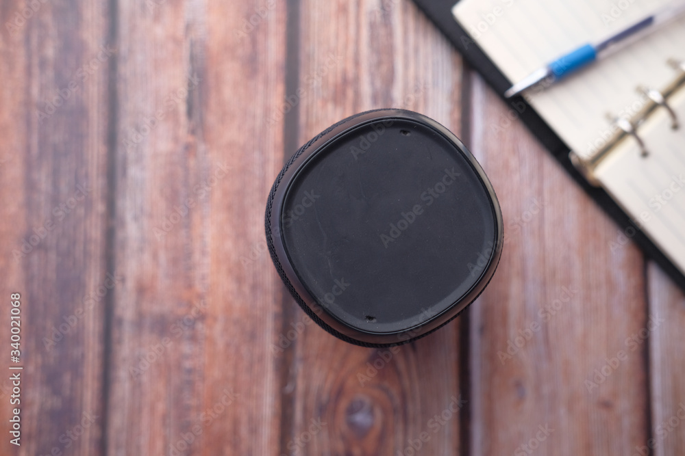 smart speaker and notepad on wooden table. smart speaker and notepad on wooden table.