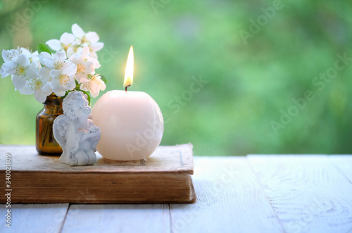 angel, candle, flowers and book. romantic relax still life. concept of faith, Christianity religion. copy space