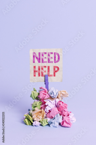 Text sign showing Need Help. Business photo text When someone is under pressure and cannot handle the situation Reminder pile colored crumpled paper clothespin reminder blue background photo