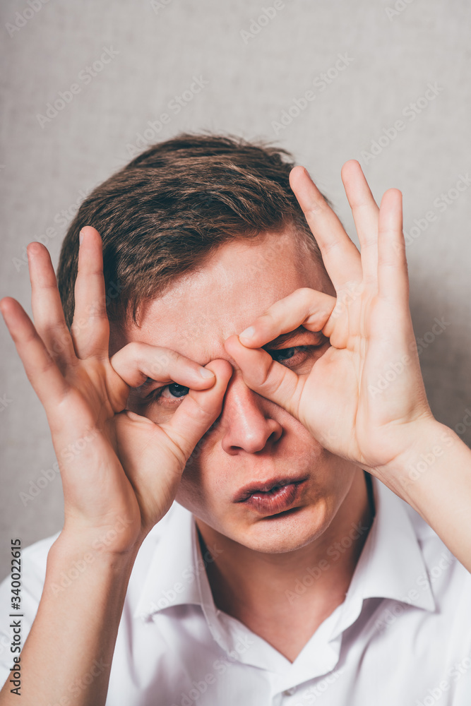 Concentrated businessman making binoculars with hands and looking through Concentrated businessman making binoculars with hands and looking through