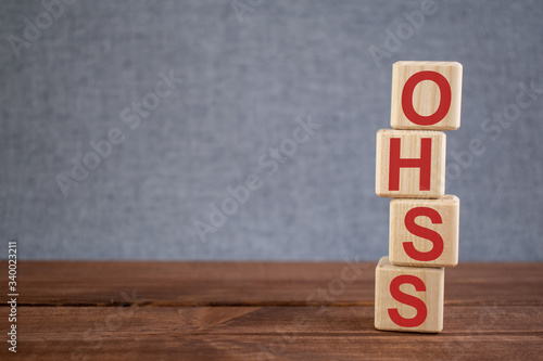Abbreviation OHSS (Ovarian HyperStimulation Syndrome) text acronym on wooden cubes on dark wooden backround. Medicine concept.