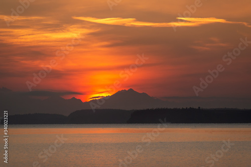Brilliant orange sunrise over mountains and water